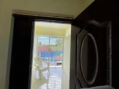 a mirror in a room with a chair and a window at Apartamento Costero 3 en Las Galeras de Samaná in Las Galeras