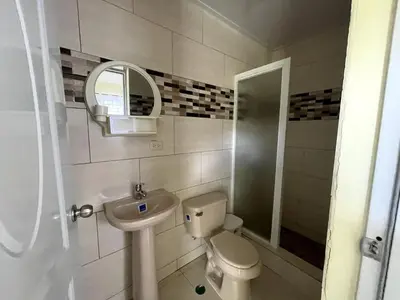 a bathroom with a sink and a toilet and a mirror at Apartamento Costero 3 en Las Galeras de Samaná in Las Galeras