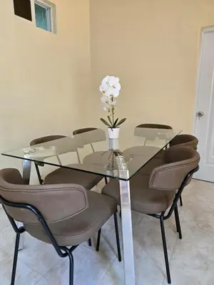 a glass dining table with chairs and a vase with flowers at Casa Madome in Pedernales