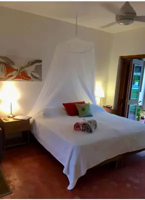 a bedroom with a white bed with a white canopy at Lovely Beach Apartment in Tranquil Playa Bonita in Las Terrenas