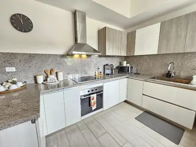 a kitchen with white cabinets and a clock on the wall at Luxury Apt with Pool Golf View in Hard Rock Golf in Punta Cana