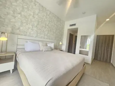 a bedroom with a large white bed and a window at Luxury Apt with Pool Golf View in Hard Rock Golf in Punta Cana