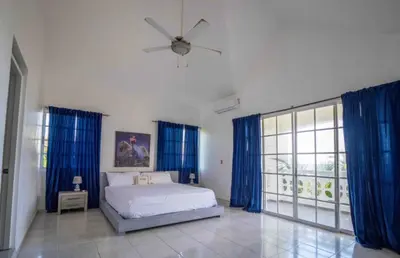 a bedroom with a bed and a ceiling fan at Villa with Oceanviews for All Types of Travelers in San Felipe de Puerto Plata