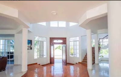 a living room with a vaulted ceiling and a hallway at Villa with Oceanviews for All Types of Travelers in San Felipe de Puerto Plata