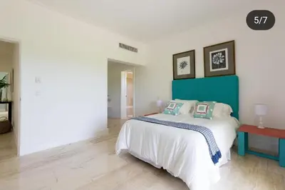a bedroom with a bed with a blue headboard at Suite tropical in Punta Cana