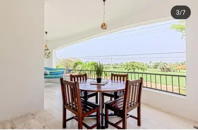 a dining room with a table and chairs and a balcony at Suite tropical in Punta Cana