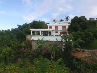 a white house on top of a hill with trees at The Nest, a quiet refuge with impressive views in Las Terrenas