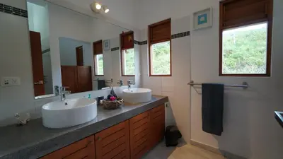 a bathroom with two sinks and a large mirror at The Nest, a quiet refuge with impressive views in Las Terrenas
