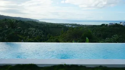 a large swimming pool with a view of the ocean at The Nest, a quiet refuge with impressive views in Las Terrenas