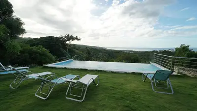a group of chairs sitting next to a swimming pool at The Nest, a quiet refuge with impressive views in Las Terrenas