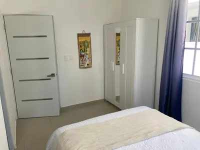 a bedroom with a bed and a closet and a door at Luxury Beach flat in Bávaro Puntacana! in Punta Cana