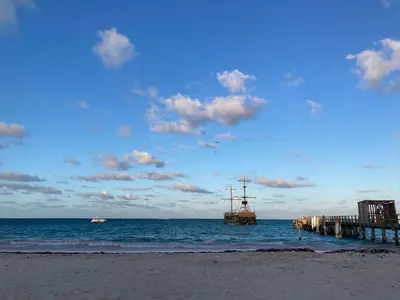 a beach with a pier and boats in the water at Luxury Beach flat in Bávaro Puntacana! in Punta Cana