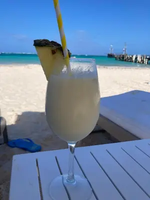 a drink with a straw in a glass on the beach at Luxury Beach flat in Bávaro Puntacana! in Punta Cana
