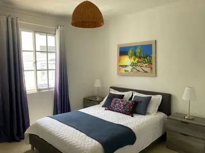 a bedroom with a bed with pillows and a window at Luxury Beach flat in Bávaro Puntacana! in Punta Cana