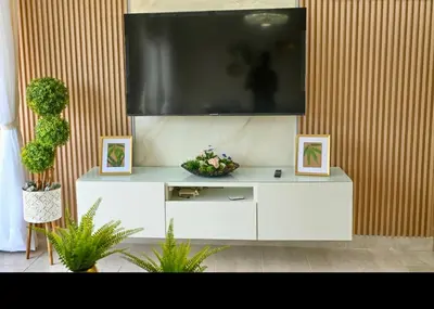 a white entertainment center with a large television on a wall at Modern Colonial Water View in Calero