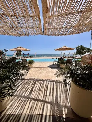a view of a beach with umbrellas and the ocean at Villa Barbara, serviced accommodation in the heart of Puntarena beach club in Sabana Buey