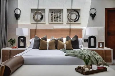 a bedroom with a large bed with pillows and mirrors at Villa Barbara, serviced accommodation in the heart of Puntarena beach club in Sabana Buey