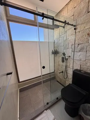 a bathroom with a glass shower with a toilet at Villa Barbara, serviced accommodation in the heart of Puntarena beach club in Sabana Buey