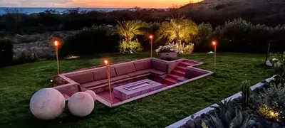 a pink couch sitting in the middle of a yard at Villa Barbara, serviced accommodation in the heart of Puntarena beach club in Sabana Buey