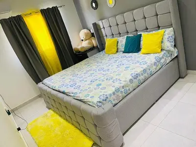a bed with yellow and blue pillows and a teddy bear at Villakeyden1 in Colorado