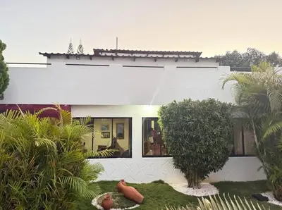 a white house with a garden in front of it at Villa Luddy Beach & Relax in Juan Dolio