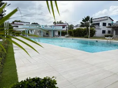a swimming pool in front of a building at Villa Luddy Beach & Relax in Juan Dolio