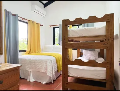 a bedroom with a bunk bed with yellow curtains at Villa Luddy Beach & Relax in Juan Dolio