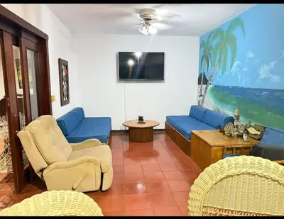 a living room with blue furniture and a tv at Villa Luddy Beach & Relax in Juan Dolio