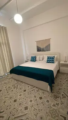 a bedroom with a large bed with blue pillows at Hotel Boutique Brisas Colonial in Santo Domingo