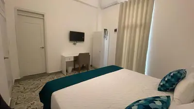 a bedroom with a bed and a desk and a television at Hotel Boutique Brisas Colonial in Santo Domingo