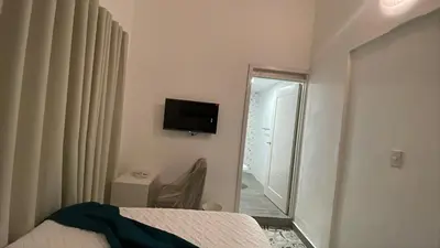 a bedroom with a bed and a mirror and a television at Hotel Boutique Brisas Colonial in Santo Domingo