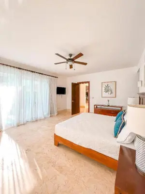 a bedroom with a bed and a ceiling fan at Cofresi Villas in Maggiolo