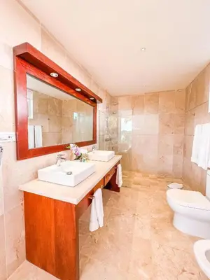 a bathroom with two sinks and a toilet and a mirror at Cofresi Villas in Maggiolo