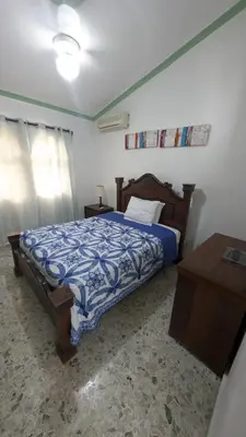 a bedroom with a bed with a blue and white comforter at Cofresi Villas in Maggiolo
