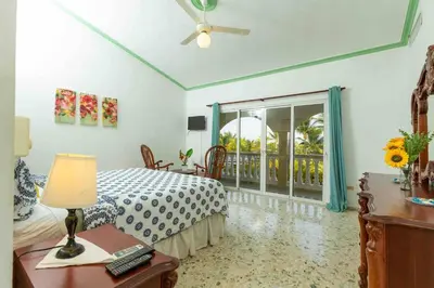a bedroom with a bed and a table with a lamp at Cofresi Villas in Maggiolo