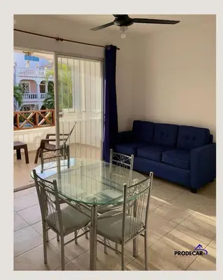a glass table and chairs in a living room with a couch at apartment for rent in Bayahibe