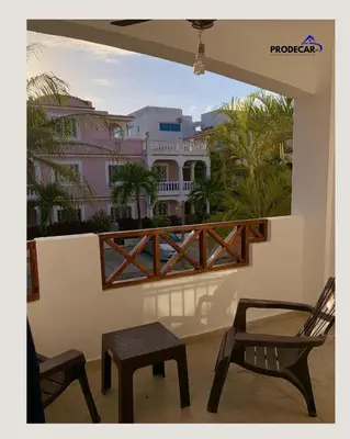 a balcony with two chairs and a table and a building at apartment for rent in Bayahibe