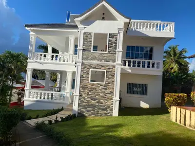 a white house with a balcony on a lawn at Lunamare Residence in Los Grini