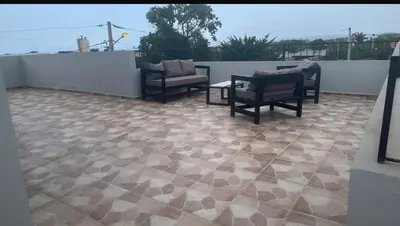 a patio with chairs and a table on a roof at Los laureles in Puerto Plata