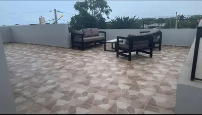 a patio with chairs and a table on a roof at Los laureles in Puerto Plata