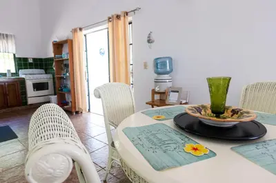 a dining room with a table with a vase on it at Playa Grande House in Las Galeras