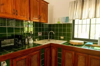 a kitchen with green tiled walls and a sink at Playa Grande House in Las Galeras