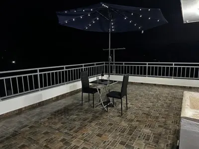 a table and chairs on a balcony with an umbrella at Hermoso Apartamento en 3er nivel con terraza privada in Bonao