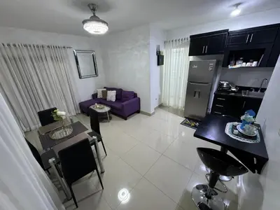 a living room with a purple couch and a kitchen at Hermoso Apartamento en 3er nivel con terraza privada in Bonao