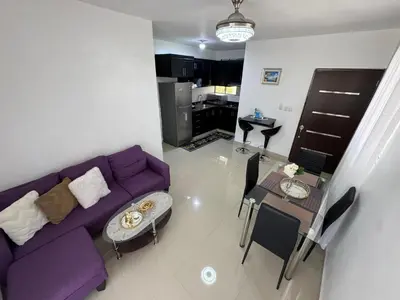 a living room with a purple couch and a table at Hermoso Apartamento en 3er nivel con terraza privada in Bonao