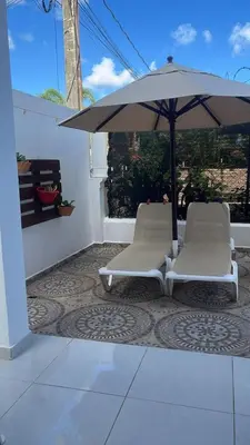 two chairs and an umbrella on a patio at Villa Tropical Paradise Pool Rooftop in San Felipe de Puerto Plata