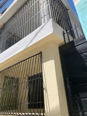 a building with a black door and a balcony at Acogedor apartamento de 1 dormitorio cerca de la playa in Sosúa