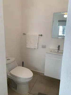 a white bathroom with a toilet and a sink at Acogedor apartamento de 1 dormitorio cerca de la playa in Sosúa