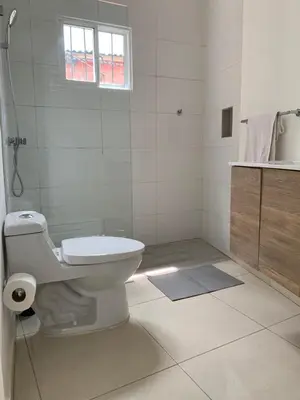 a white bathroom with a toilet and a sink at Acogedor apartamento de 1 dormitorio cerca de la playa in Sosúa