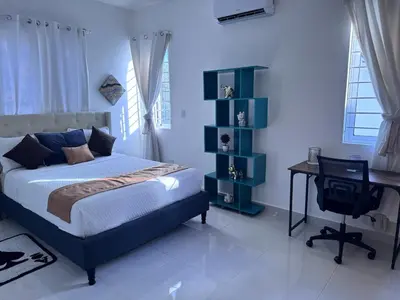 a bedroom with a bed and a desk and a computer at Villa Tropical Paradise Pool Rooftop in San Felipe de Puerto Plata